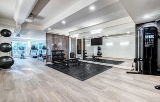 a home gym with weights and exercise equipment and a television
