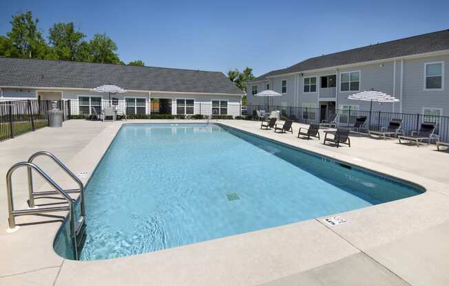 our apartments have a large swimming pool with chairs and umbrellas