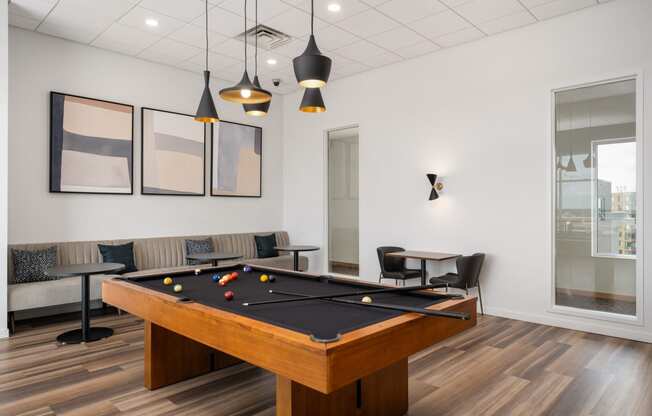 a billiards table in a game room with couches and tables