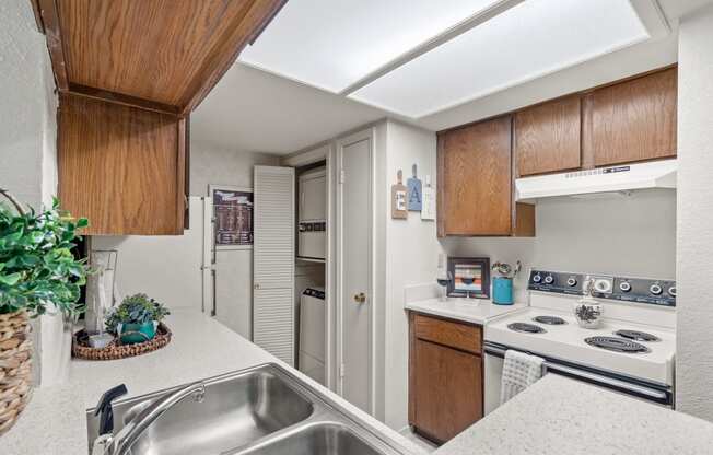 a kitchen with white countertops and a stainless steel sink