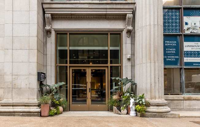 the front of a building with a bronze door and potted plants at The Commonwealth Building, Pittsburgh, Pennsylvania