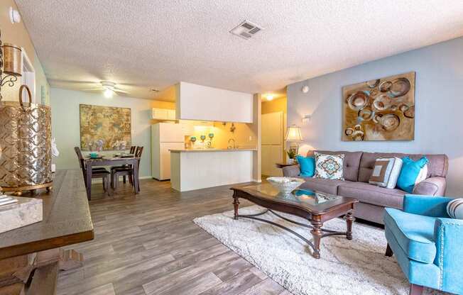 A living room with a brown coffee table and a blue chair.