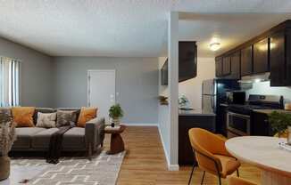 a living room and kitchen with a couch and a table