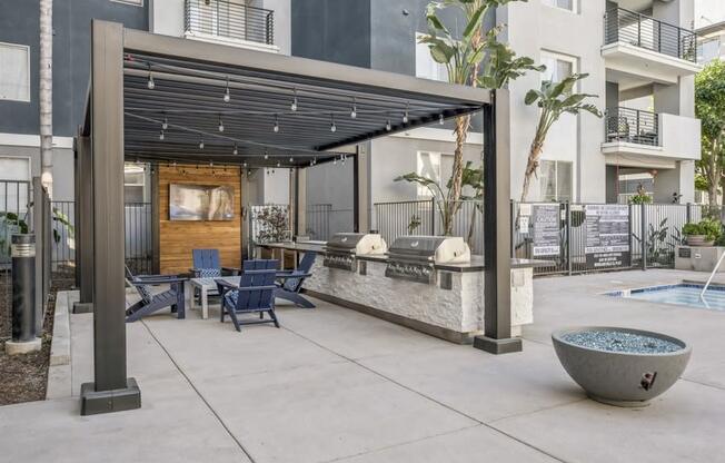 a patio with a pool and chairs and a pergola