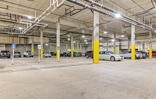 a parking garage with cars parked in it and yellow pillars