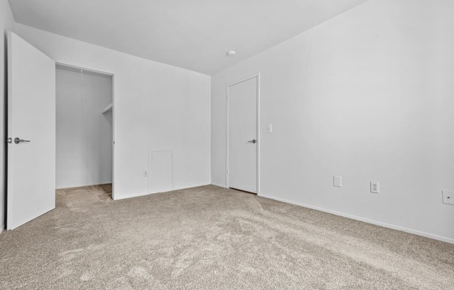 a bedroom with white walls and carpet