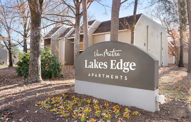 A sign for Van Metre Lakes Edge Apartments is in front of some buildings.