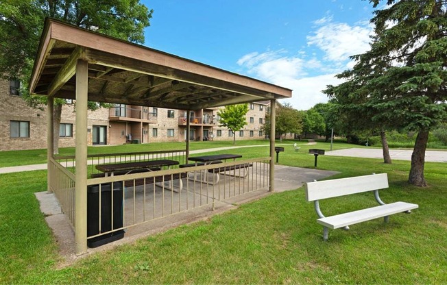 a picnic table and a bench in a park