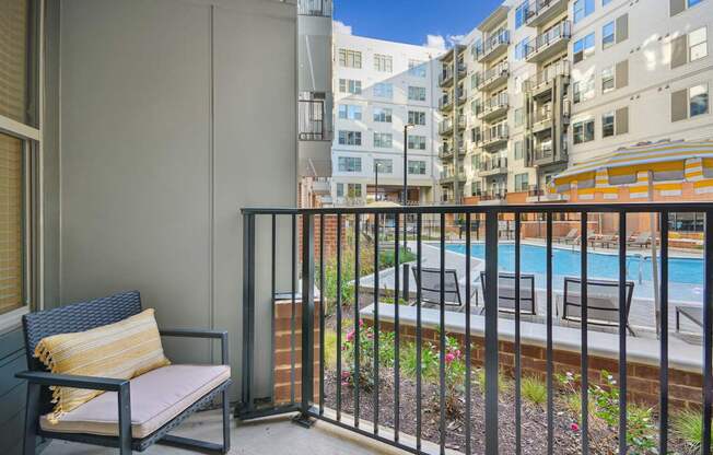 the view of a pool from a balcony with a chair at Link Apartments® Calyx, Chapel Hill