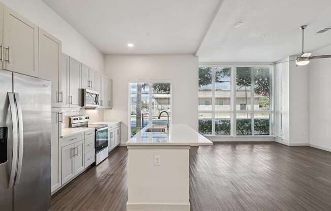 A kitchen with a refrigerator, microwave, and oven.