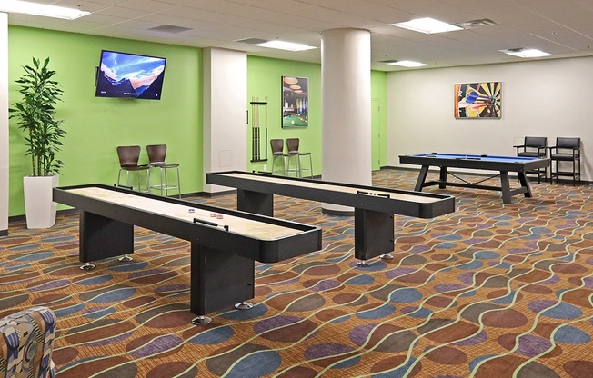 A room with a pool table and a TV on the wall.