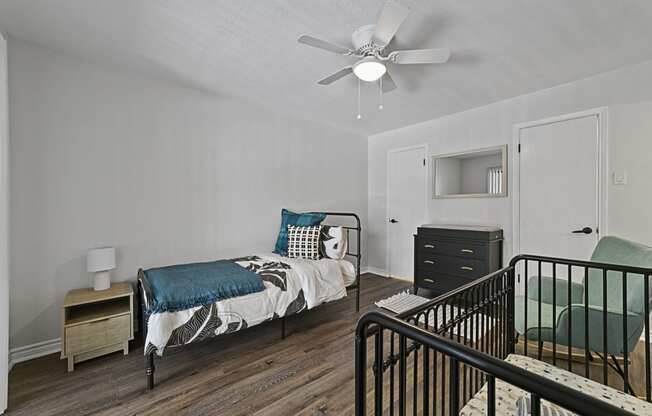 Bedroom with cozy bed and light a bedroom with a bed and a ceiling fan at Lakeside Apartments, Dallas, TX