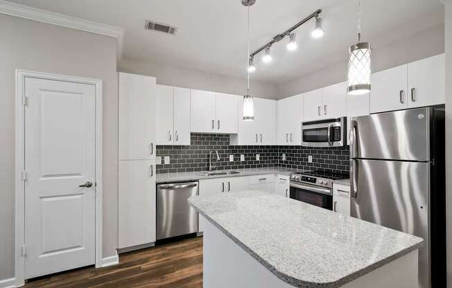A kitchen with a white counter top and stainless steel appliances.