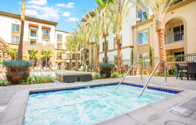 a swimming pool with palm trees and apartments in the background