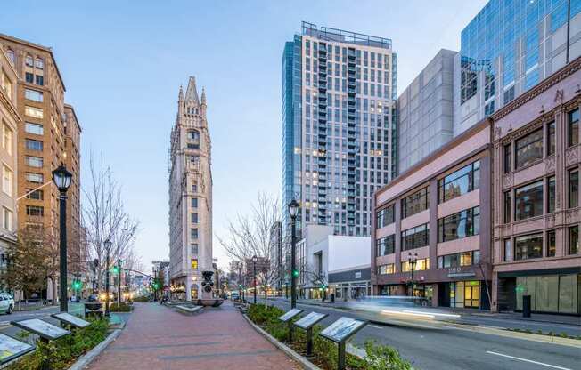 A city street with a tall building in the background.