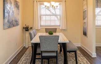 A dining room with a table and chairs.