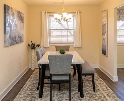 A dining room with a table and chairs.