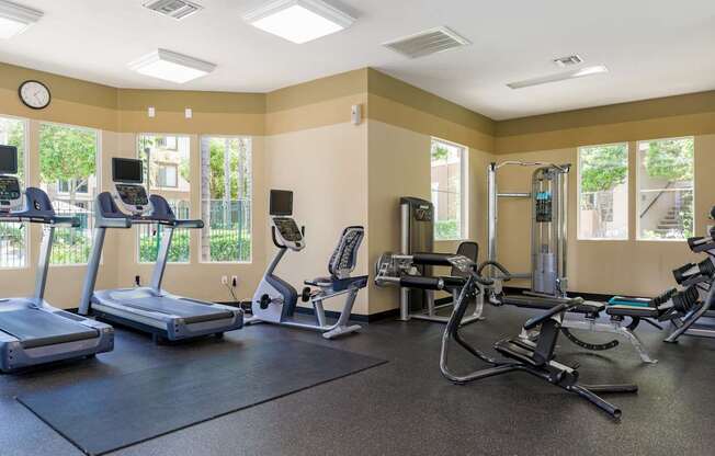 A gym with treadmills, elliptical machines, and other exercise equipment.