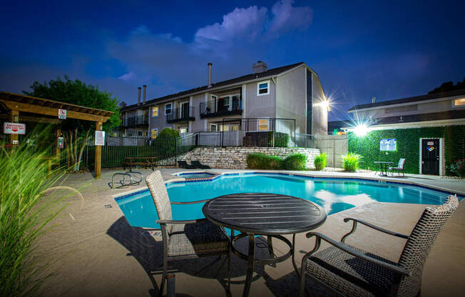 A pool area with a table and chairs.