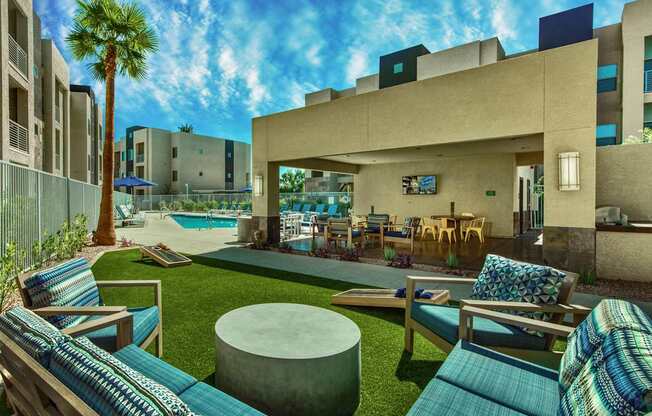 A modern outdoor seating area with a pool and palm tree.