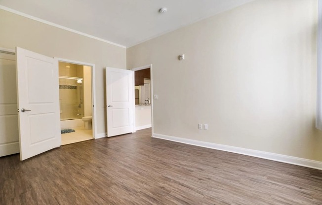 an empty living room with white walls and wood flooring