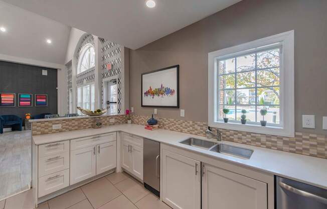 A kitchen with a large window and a sink.