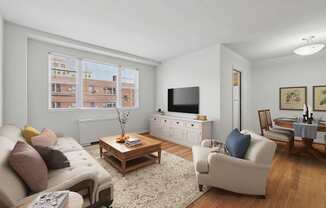 A living room with a couch, a coffee table, and a television.