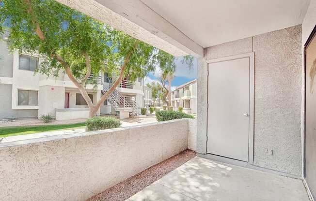 A white door is on the right side of a concrete wall.