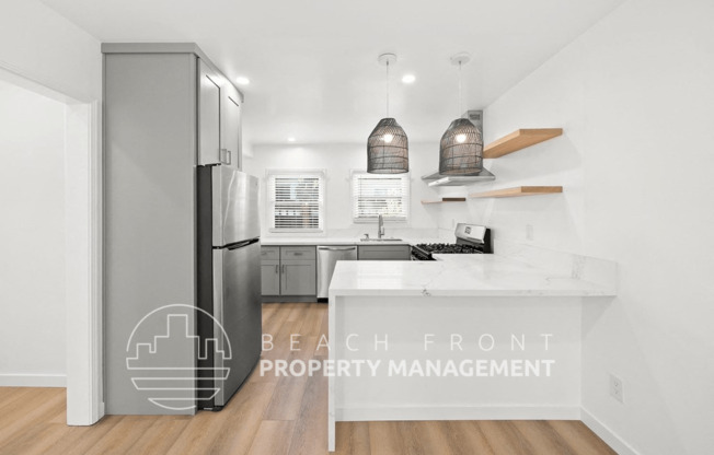 a kitchen with a white counter top and a stainless steel refrigerator