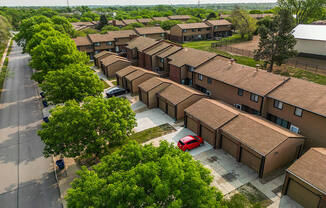 arial view of a housing complex with a red car parked in the parking lot