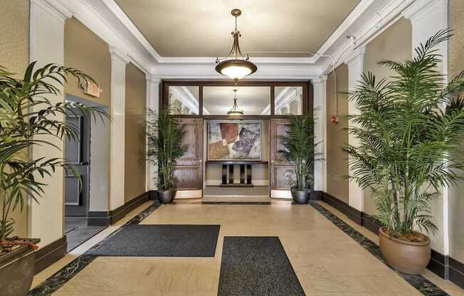 a lobby with potted plants and a large glass door at The Knights @ 506 Delaware Apartments, Buffalo, New York