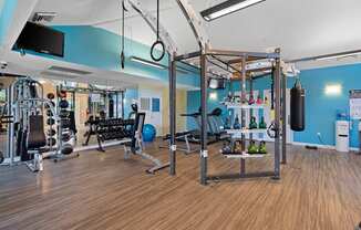 a gym with weights and other gym equipment on a wood floor