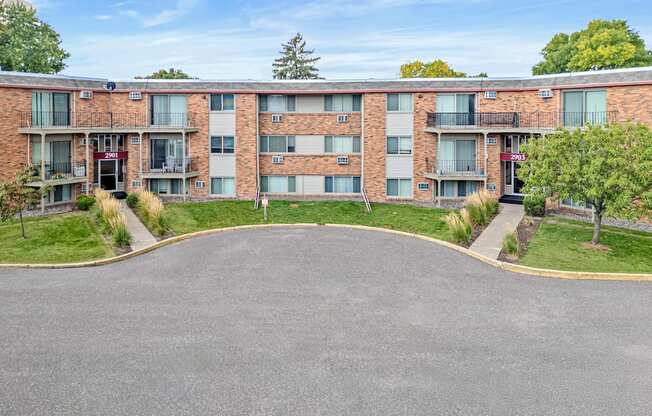 A large apartment complex with a parking lot in front.