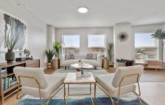 Bright apartment living room with wood-style flooring and large windows at River 595