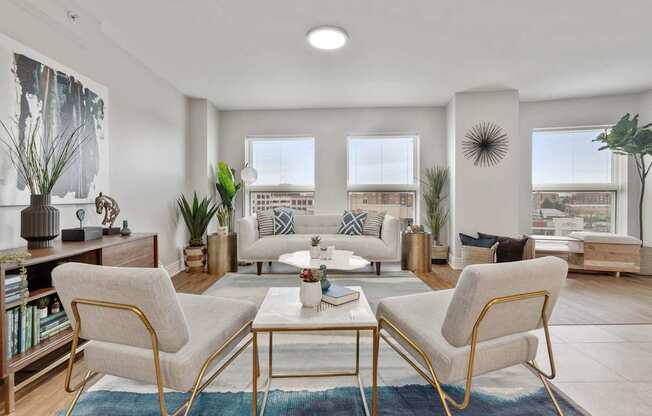 Bright apartment living room with wood-style flooring and large windows at River 595