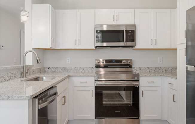 a kitchen with white cabinets and stainless steel appliances