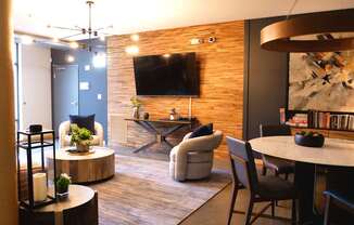 A modern living room with a flat screen TV mounted on the wall.