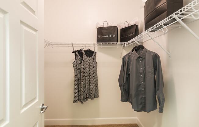 a closet with clothes hanging on a rack and a door