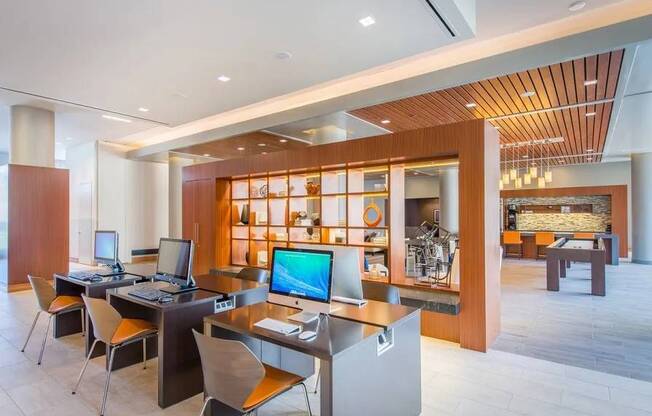 A modern home office with a wooden ceiling and a desk with a computer and monitor.