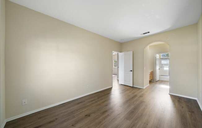 a bedroom with hardwood floors and beige walls at The Village Apartments, Van Nuys, 91406