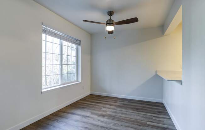 Apartments for Rent in Everett, Washington - Woodbrook - Dining Room with Wood-Style Flooring, Ceiling Fan, and Large Window.