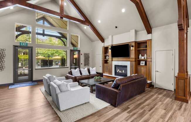 a spacious living room with a vaulted ceiling and a large window with a view of the