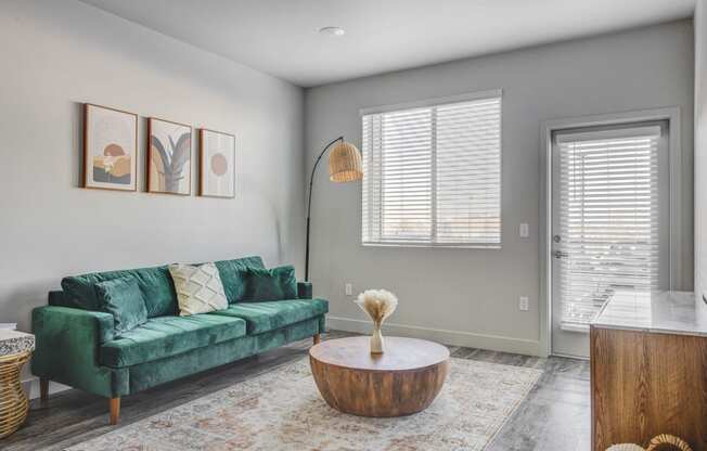 a living room with a green couch and a coffee table