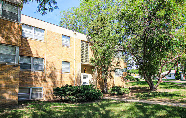 a large brick apartment building with trees in front of it