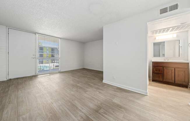 a bedroom with a large window and hardwood floors