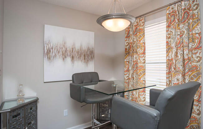 an office with chairs and a table with a glass desk