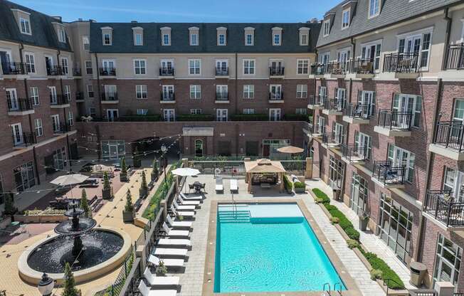 A large pool surrounded by a fence and a building in the background.