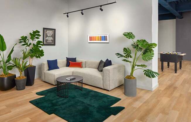 A living room with a white couch, a green rug, and a coffee table.