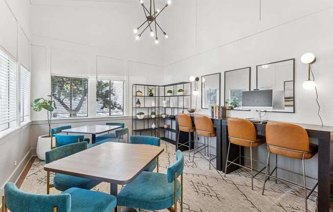 A room with a table and chairs and a shelf with pictures.