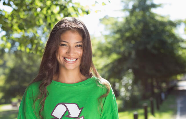 a girl smiling and wearing a green shirt